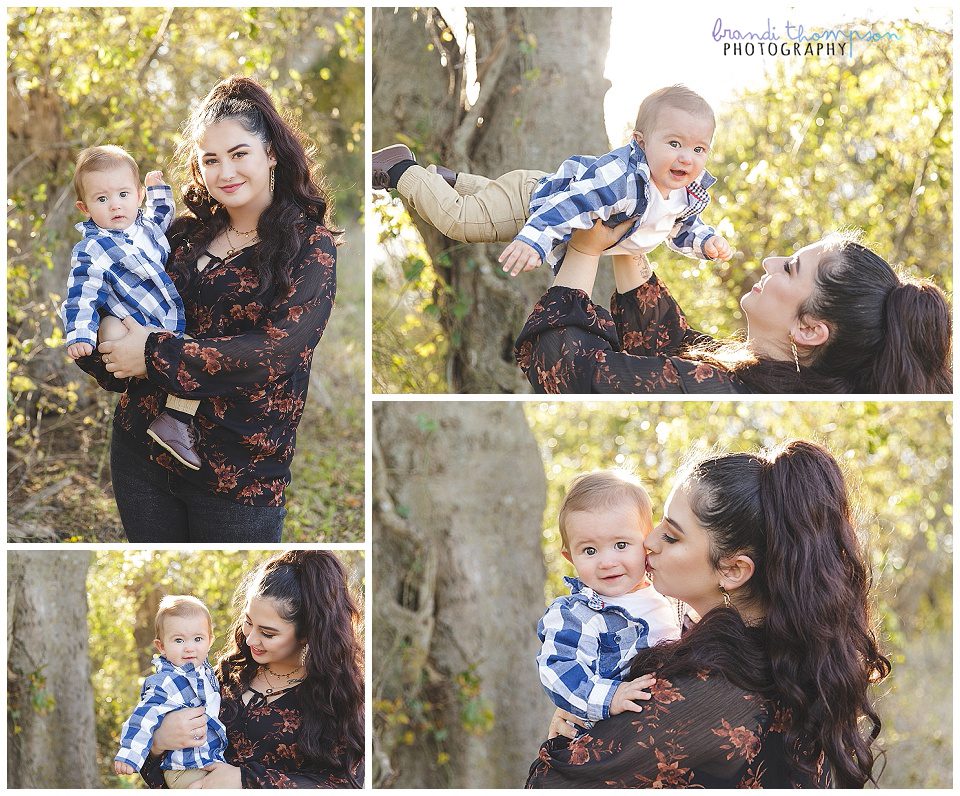 outdoor photos of mother and infant son with green rustic background - they have light skin. Mom has long dark hair and is wearing black shirt and pants, and her son is wearing a blue plaid button down over a white tee shirt, with khaki pants